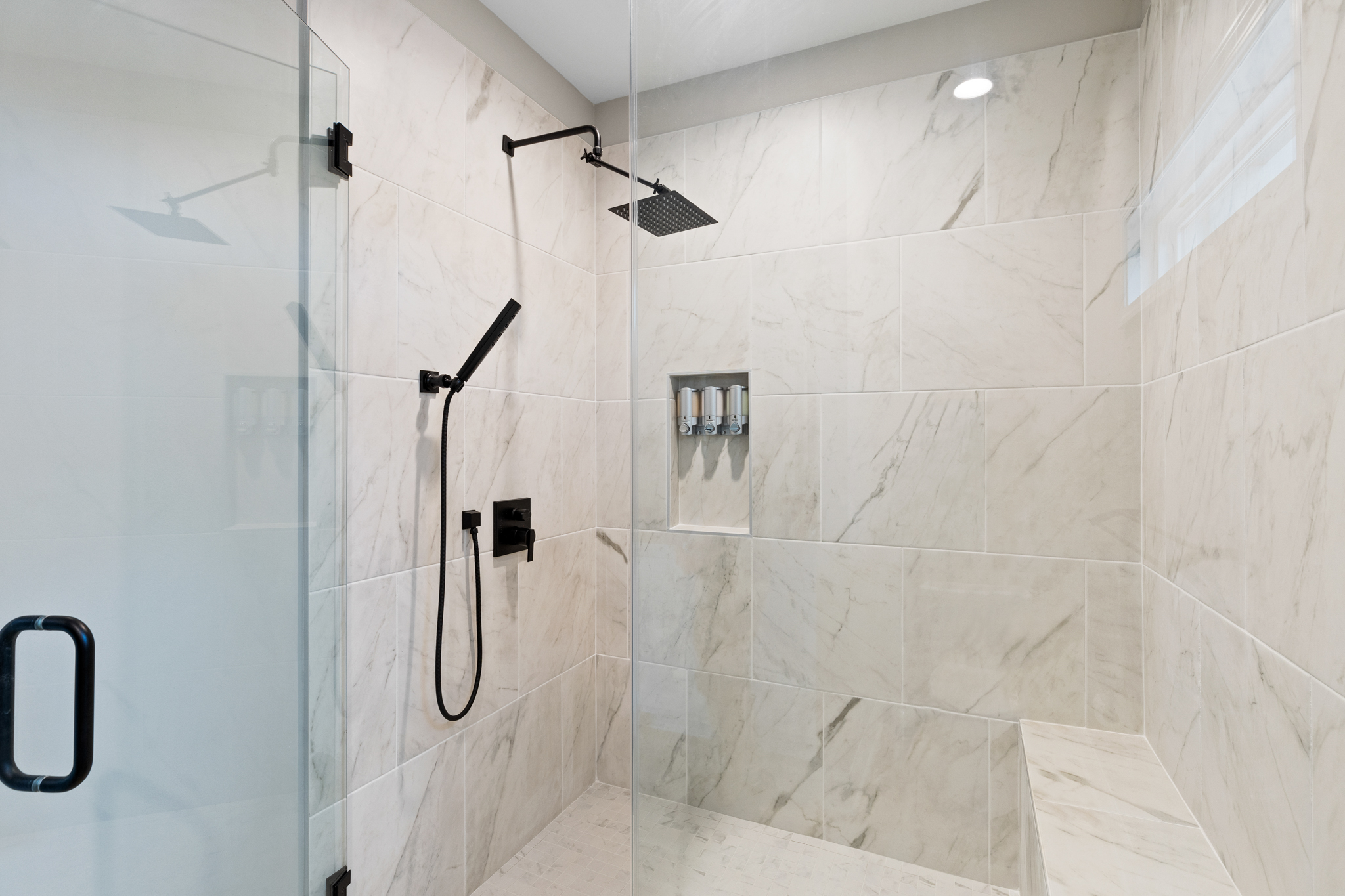 Shower detail showing dual heads and dispenser niche