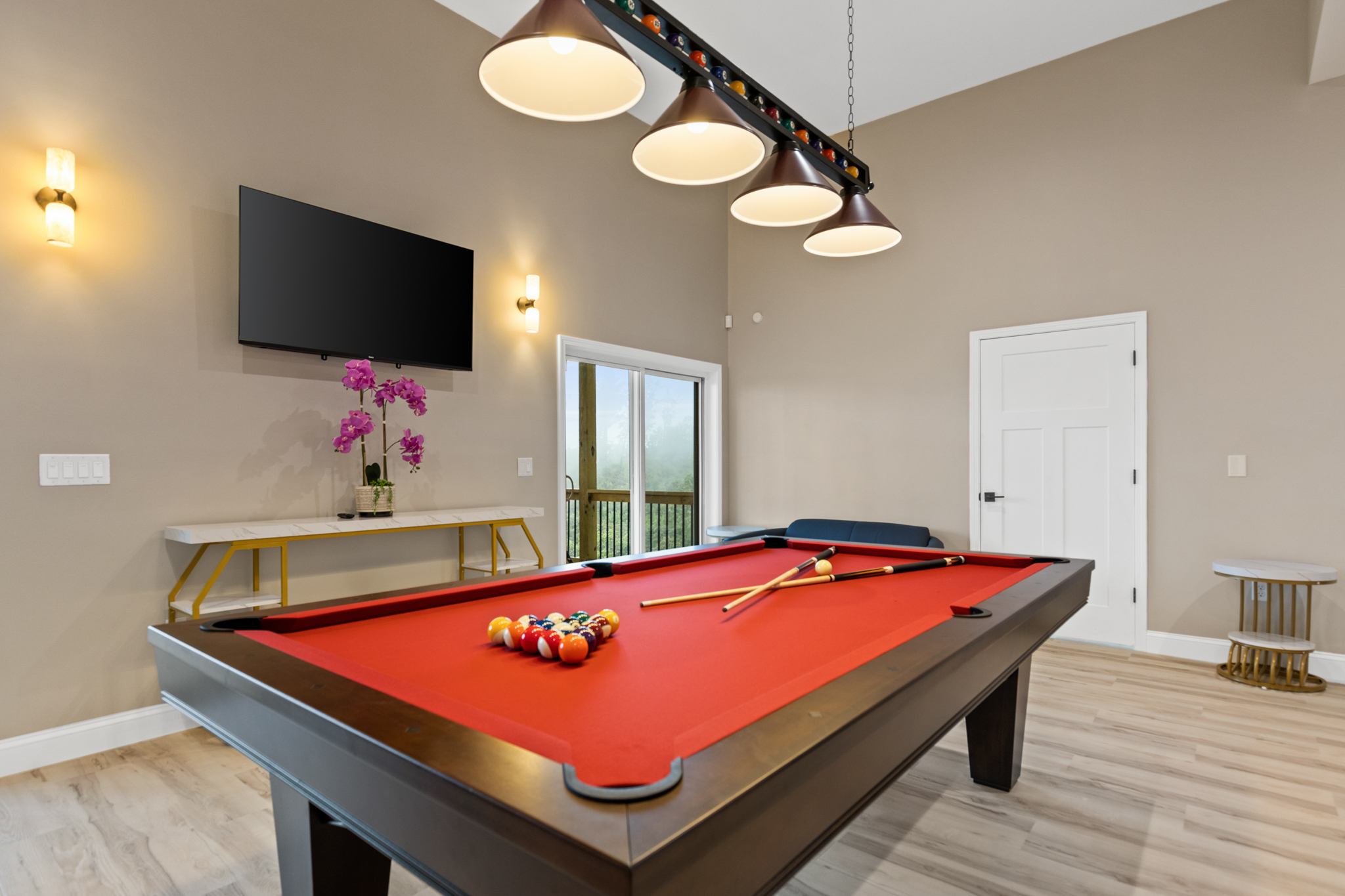 Game room with red felt pool table and stylish lighting