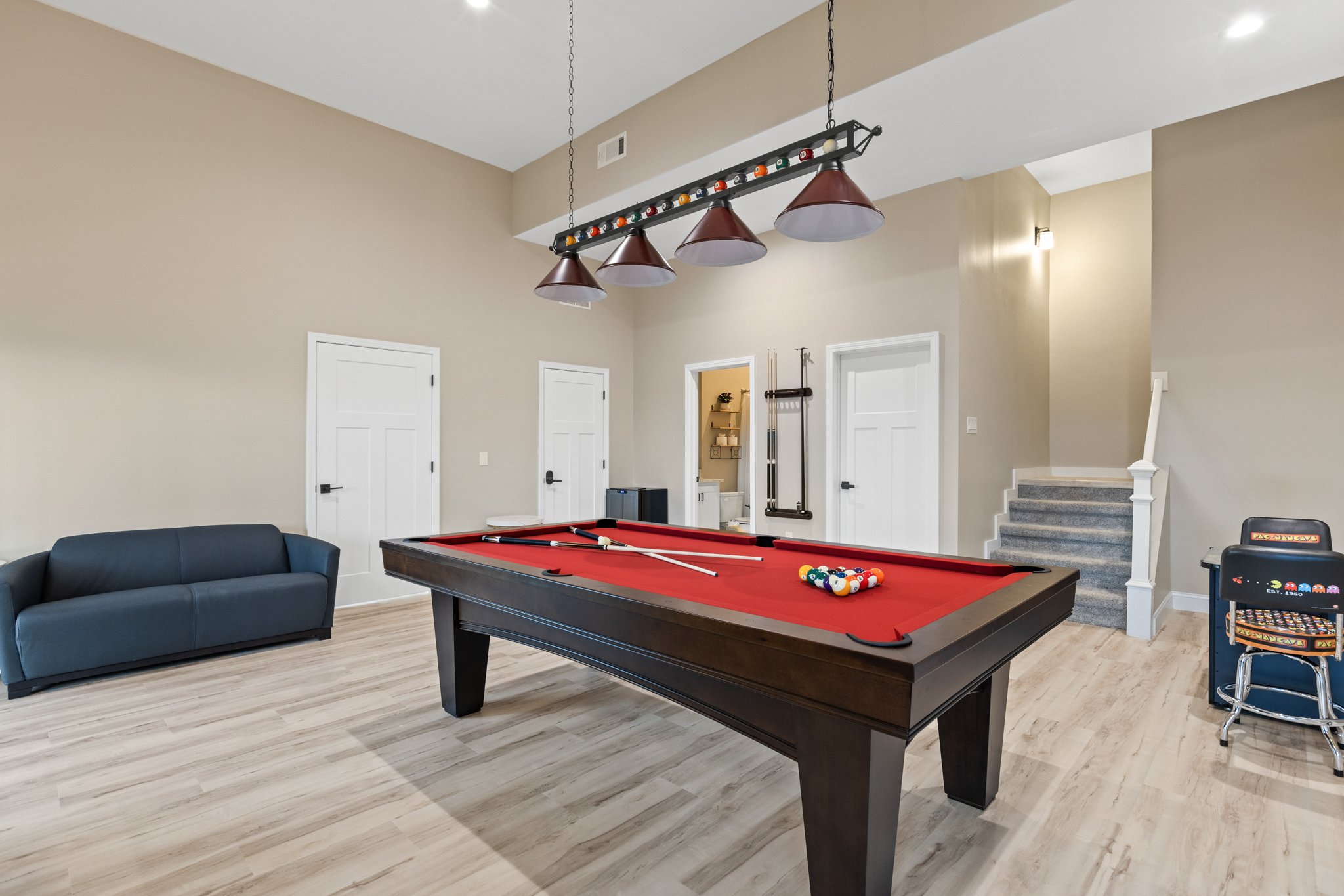 Game room showing pool table, seating, and arcade games