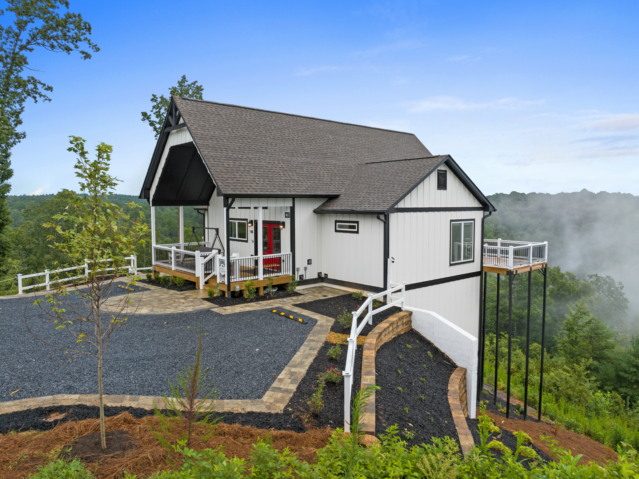 Side view of cabin showing deck and landscaping at twilight
