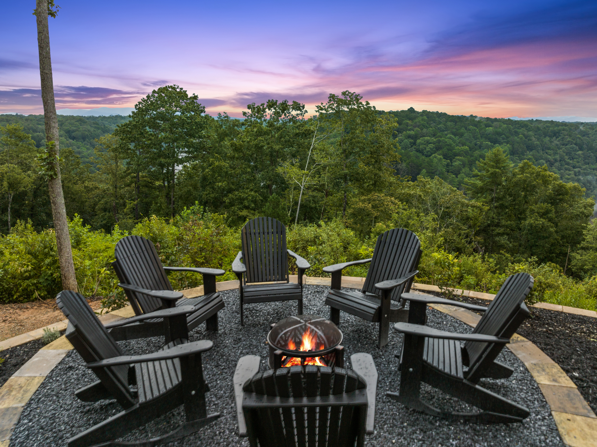 Fire pit area with Adirondack chairs and sunset sky