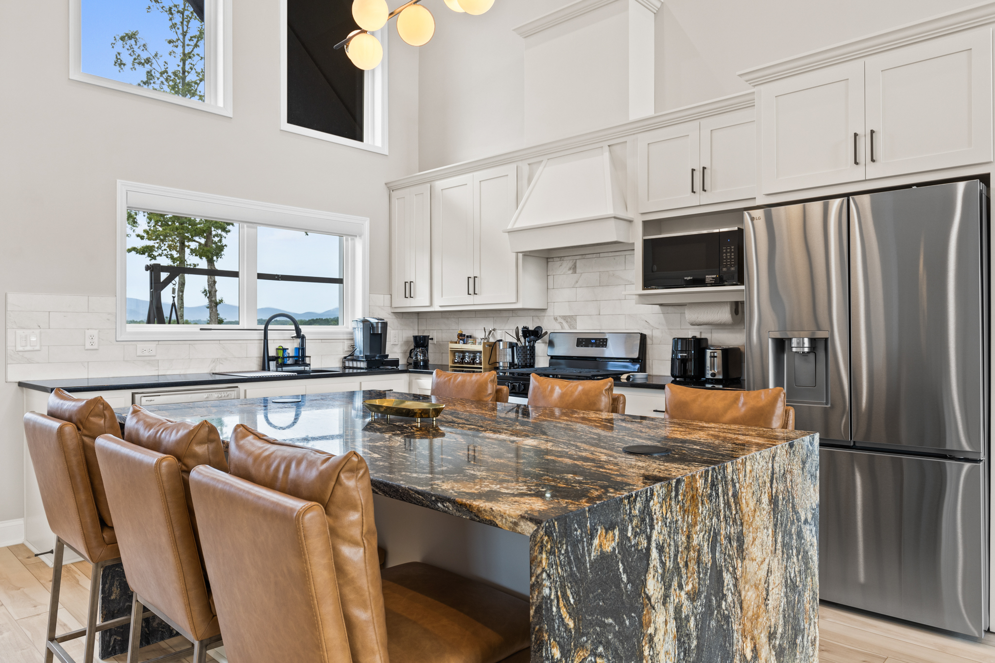 Kitchen island with leather bar seating and mountain views