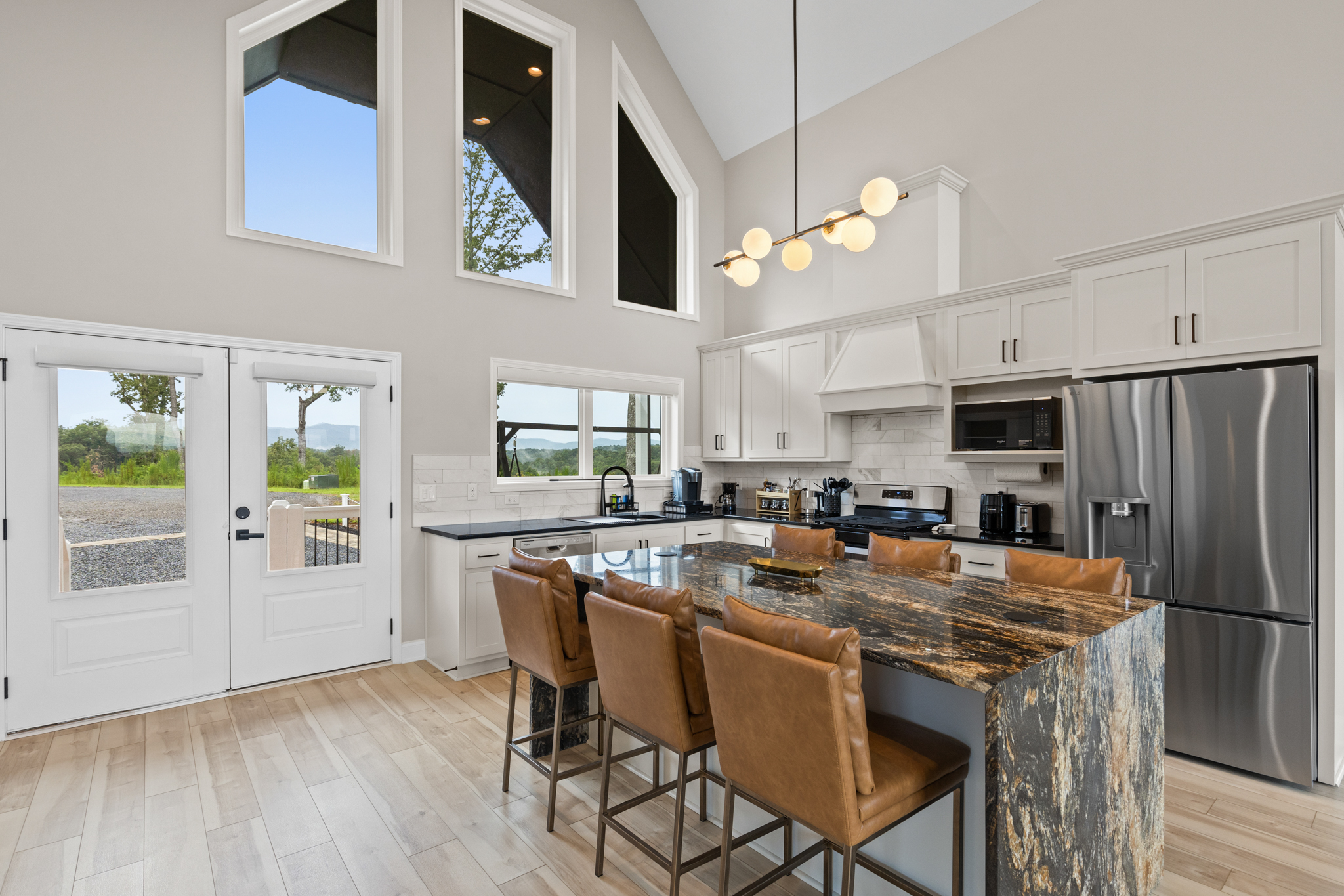 Gourmet kitchen with waterfall granite island and vaulted ceilings